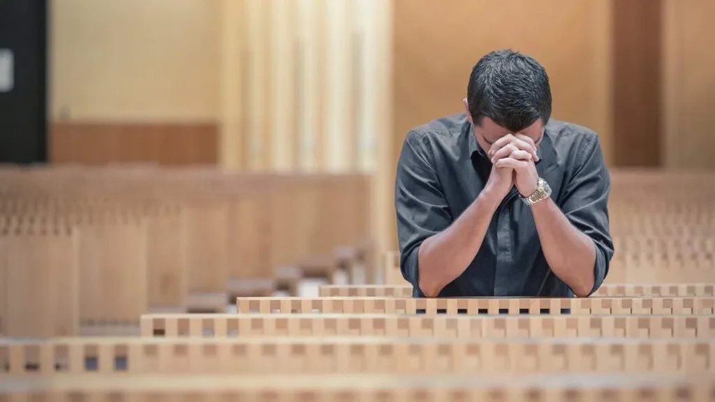 Imagem Homem ajoelhado rezando sozinho na igreja do artigo 48485293-ea15-425c-b95d-e92e8f92da45