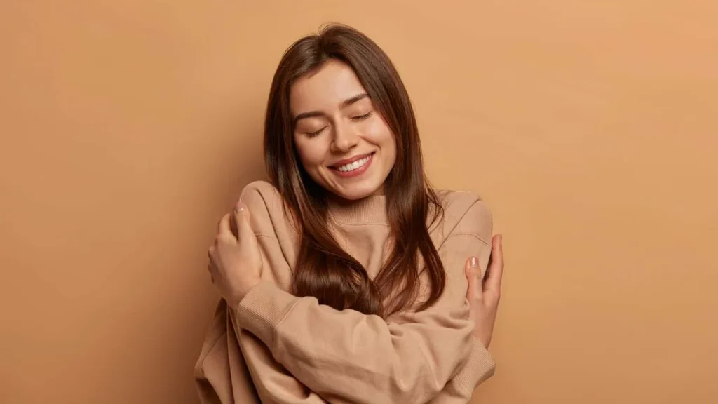 Imagem Mulher e abracando em um gesto de amor proprio do artigo Autoestima e bem-estar: um convite ao autoconhecimento